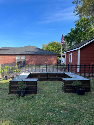 Metal raised garden beds in backyard with potted plants, ideal for American gardeners seeking durable, eco-friendly solutions.