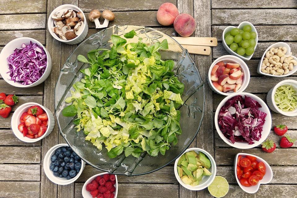 Fresh garden salad with mixed greens, berries, and veggies on rustic wood table