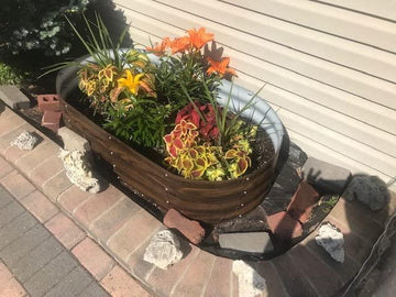 Metal raised garden bed with vibrant flowers, styled on brick patio near home siding